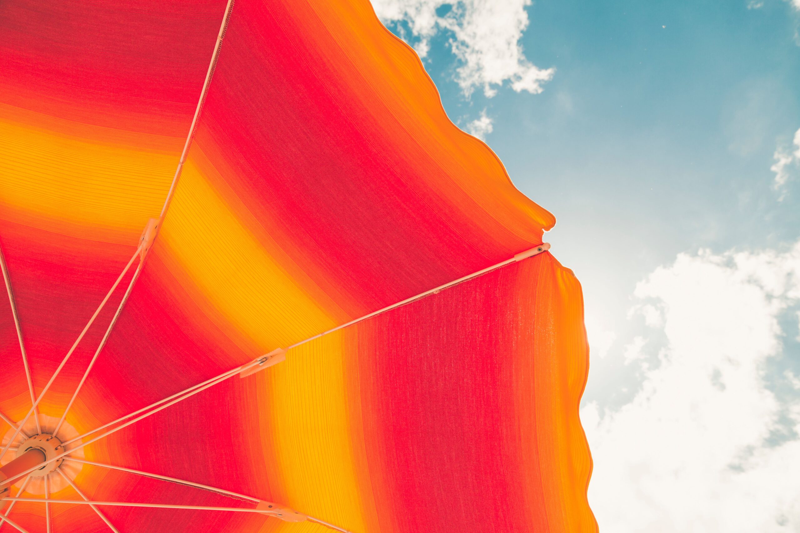 Low angle photo of red and orange umbrella